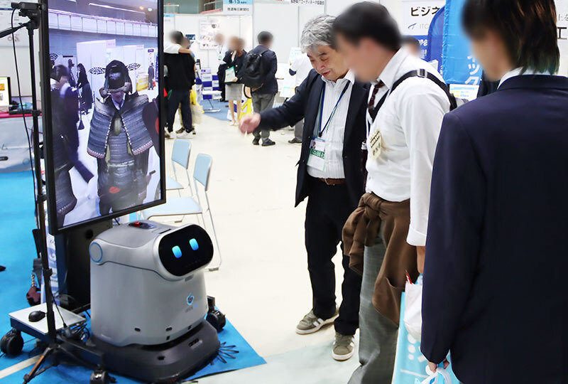 産業フェアで展示ロボットを紹介する様子
